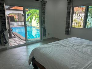 a bedroom with a bed and a view of a pool at Nirvana pool villa 2 in Nong Prue