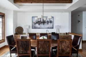 a dining room with a wooden table and chairs at Luxury Suite 6A by Moonlight Basin Lodging in Big Sky