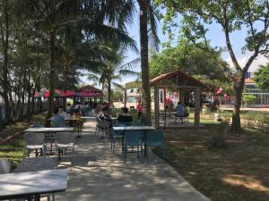 a group of people sitting at tables in a park at Sen Vàng in Diễn Châu