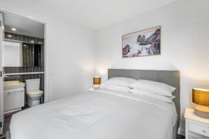 - une chambre blanche avec un lit blanc et une salle de bains dans l'établissement 2-Bed Inner-City Pad Bright with Panoramic Views, à Melbourne