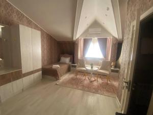 - un salon avec une table, des chaises et un lit dans l'établissement Renaissance Boutique Hotel, à Samarcande