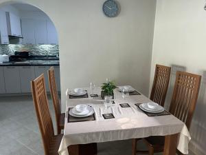 a dining room table with chairs and a clock on the wall at Nirvana pool villa 2 in Nong Prue