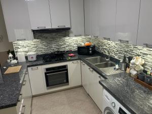 a kitchen with white cabinets and a sink at Nirvana pool villa 2 in Nong Prue