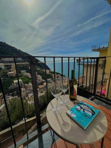 einen Tisch mit Gläsern und Weinflaschen auf dem Balkon in der Unterkunft The Upper House in Riomaggiore