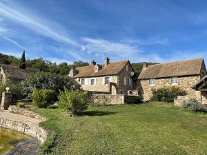 ein altes Steinhaus mit einem Rasenhof davor in der Unterkunft gite seccotine in Saint-Mard-de-Vaux