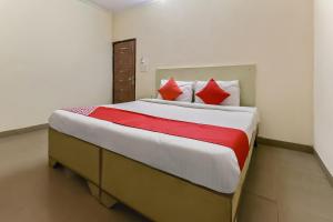 a bedroom with a large bed with red pillows at The Krishna Stays in Mathura