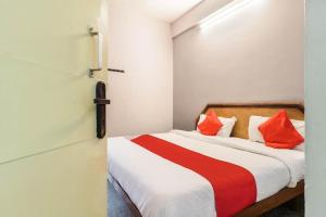 a bedroom with a bed with orange and red pillows at The Krishna Stays in Mathura