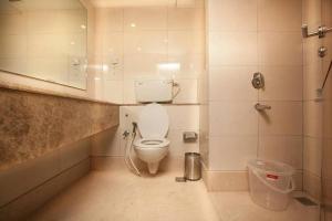 a bathroom with a toilet and a mirror at The Krishna Stays in Mathura