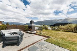 a patio with a grill and a fire place at Magic Central Wanaka Living in Wanaka