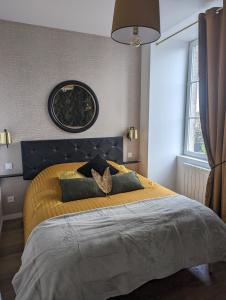 ein Schlafzimmer mit einem großen Bett mit gelber Tagesdecke in der Unterkunft la Pléiade in Pont-Hébert