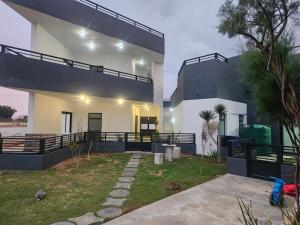 a large white house with a garden in front of it at Walvis Bay Wind Beggars in Walvis Bay