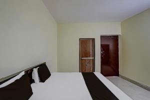 a bedroom with a white bed and a door at OYO Hotel Shivraj in Bilāspur