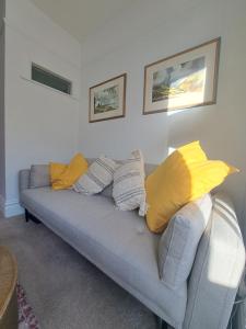 a living room with a couch with yellow pillows at The cosy nook in Barnstaple
