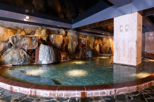 a water feature in a hotel lobby with a waterfall at Ooedo Onsen Monogatari Premium Kinugawa Kanko Hotel in Nikko