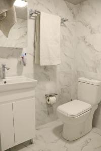Baño blanco con aseo y lavamanos en White House Hotel, en Ereván