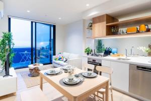 a kitchen and living room with a table and chairs at Modern 2B APT BayViews*Pool*GYM in Melbourne