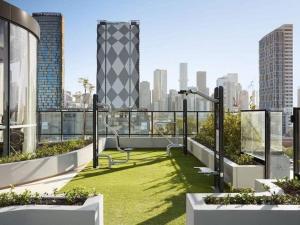 a balcony with green grass and a view of a city at Modern 2B APT BayViews*Pool*GYM in Melbourne