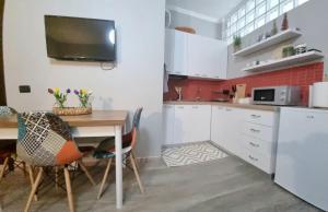 eine Küche mit einem Tisch und einem TV an der Wand in der Unterkunft Nevila's apartment in Tirana