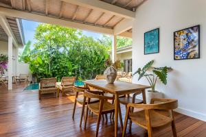 a dining room with a wooden table and chairs at RIYURI GUESTHOUSE in Tumbak Bayuh