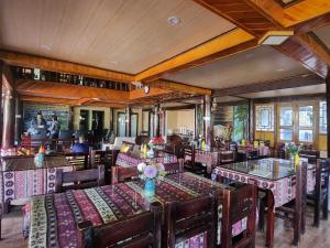 un ristorante con tavoli e sedie in una stanza di Sapa Garden Bungalow a Sa Pa