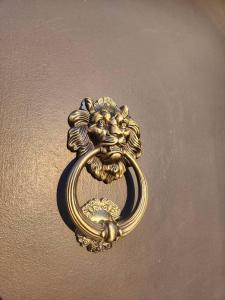 una maniglia della porta d'oro con una testa di leone su un muro di The Fairytale Cottage at High Rock Castle a Monroe