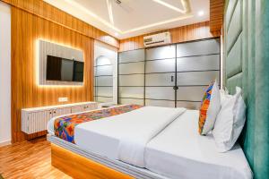 um quarto com uma cama grande e uma televisão em FabHotel Max em Vadodara