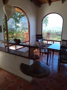 a room with a table and chairs and two windows at casa-patriana in San Ramón