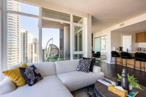 sala de estar con sofá blanco y ventana grande en Vancouver Downtown Yaletown Collection Condo, en Vancouver