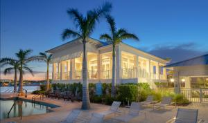 ein Haus mit einem Pool, Palmen und Stühlen in der Unterkunft The Shore House 4br-4,5ba in Key Largo