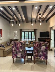 a living room with two chairs and a table at The Chapters Villa in Alibag
