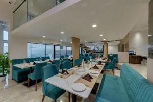 un comedor con mesas y sillas verdes en Comfort Inn Sapphire Chandkheda, Ahmedabad, en Ahmedabad