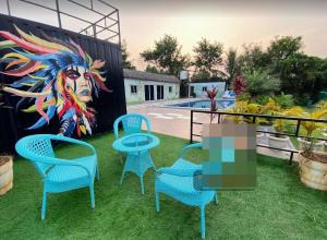um grupo de cadeiras e uma mesa em frente a um mural em Seascape Villa em Hyderabad