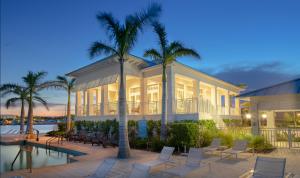 uma casa com piscina, palmeiras e cadeiras em The Sea Haven 4br-4,5ba em Key Largo