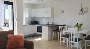 a kitchen with white cabinets and a table with chairs at Apartment Dino, Zadar in Zadar