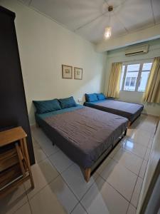 een slaapkamer met 2 bedden en een raam bij Langkawi Perdana Families Suite @ Langkawi Airport in Pantai Cenang
