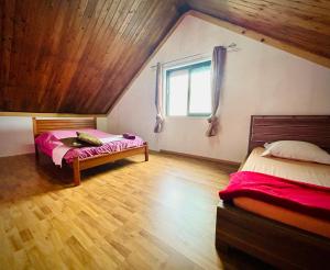 a attic bedroom with two beds and a window at La Kaz du Volcan-Capacité maximum 10 personnes in La Plaine des Cafres