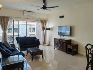 een woonkamer met een flatscreen-tv en meubels bij Langkawi Perdana Families Suite @ Langkawi Airport in Pantai Cenang