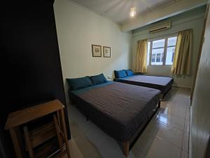 een slaapkamer met 2 bedden en een raam bij Langkawi Perdana Families Suite @ Langkawi Airport in Pantai Cenang