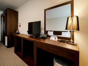 a desk with a television and a mirror in a hotel room at Hotel K-Tree Pyeongtaek in Pyeongtaek
