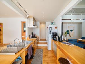 - une cuisine avec des comptoirs en bois et un réfrigérateur blanc dans l'établissement Surf&Turf Aoshima - サーフ&ターフ青島 -, à Miyazaki