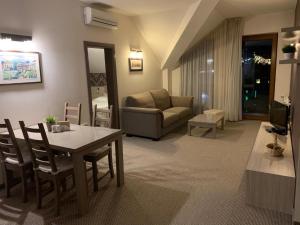 een woonkamer met een tafel en een bank bij StayInn Granat Apartments - next to Gondola Lift, perfect for 4pers n415 in Bansko