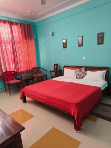 1 dormitorio con 1 cama grande con manta roja en Ayurveda Bhavan en Rishīkesh