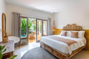 a bedroom with a large bed and a patio at RIYURI GUESTHOUSE in Tumbak Bayuh