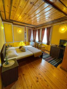 a bedroom with a large bed and a wooden ceiling at Guest rooms Colorit in Koprivshtitsa
