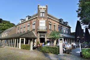 a building with people sitting at tables in front of it at Hotel Wesseling in Dwingeloo