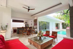 a living room with a red couch and a table at Villa Kallayaan by Optimum Bali Villas in Seminyak