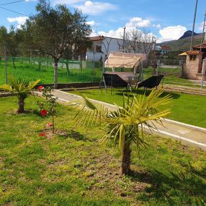 a yard with two palm trees and a tent at Villa Sunny Day Riviera in Asprovalta
