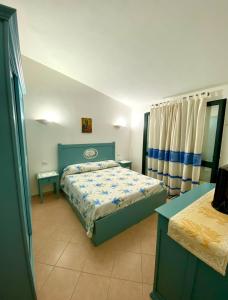 une chambre avec un lit avec une couette bleue dans l'établissement Villetta a Tanaunella, à Tanaunella