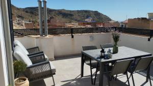 patio ze stołem i krzesłami na balkonie w obiekcie Apartamentos Elegancia w mieście Agost