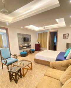 een slaapkamer met een bed, een bank en een tv bij hotel ryan in New Delhi